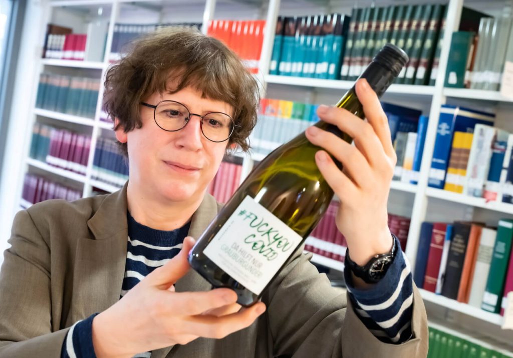 Oberkonservatorin Brigitte Heck mit einer Flasche Covid-Wein