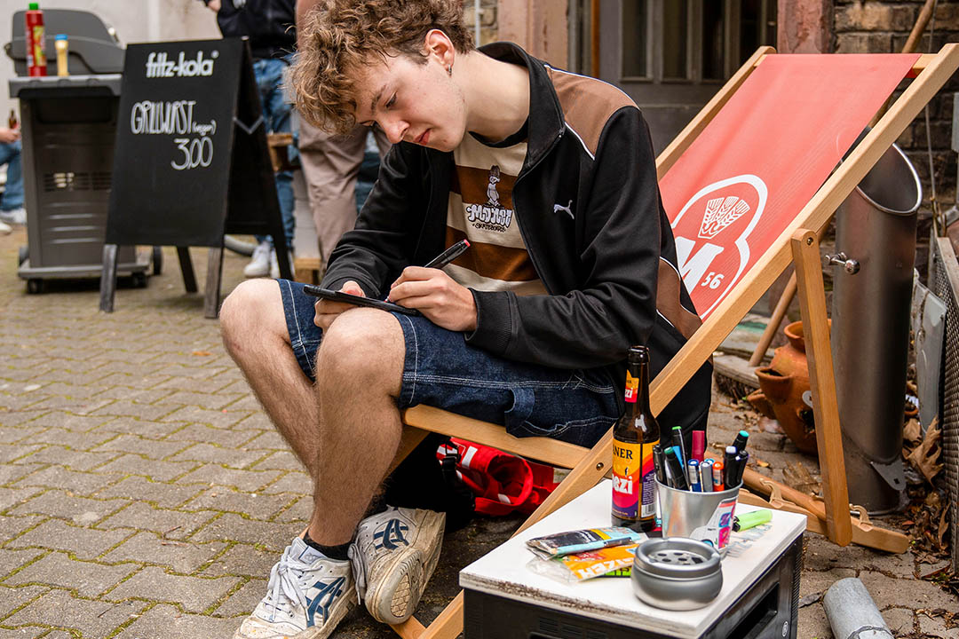 Ein Mann sitzt im Liegestuhl und zeichnet © Jule Raabe