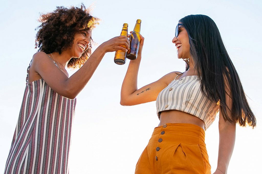 Zwei junge Frauen trinken draußen ein Bier © Kampus/Pexels