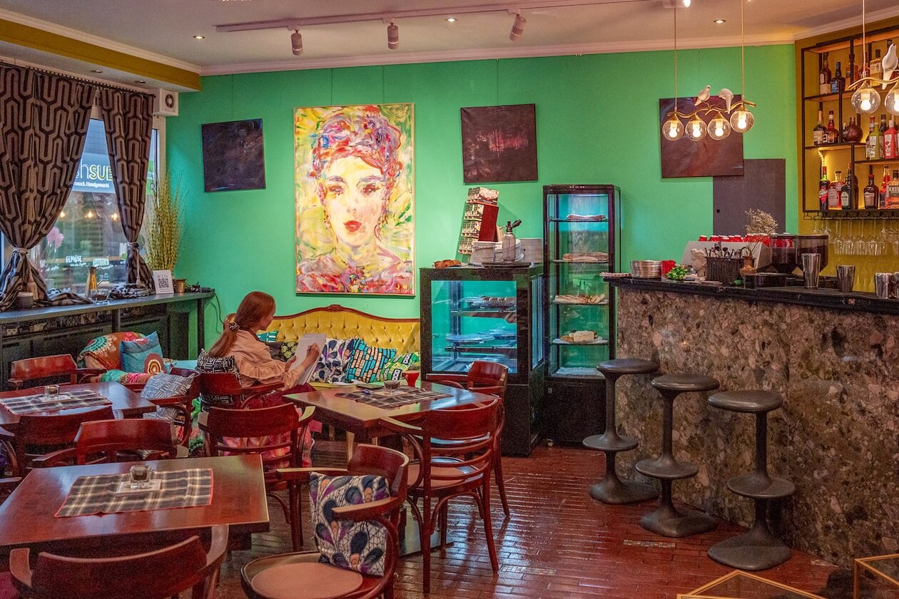 Innenraum des Cafés Dasarti in Karlsruhe mit grünen Wänen und rotbraunen Möbeln