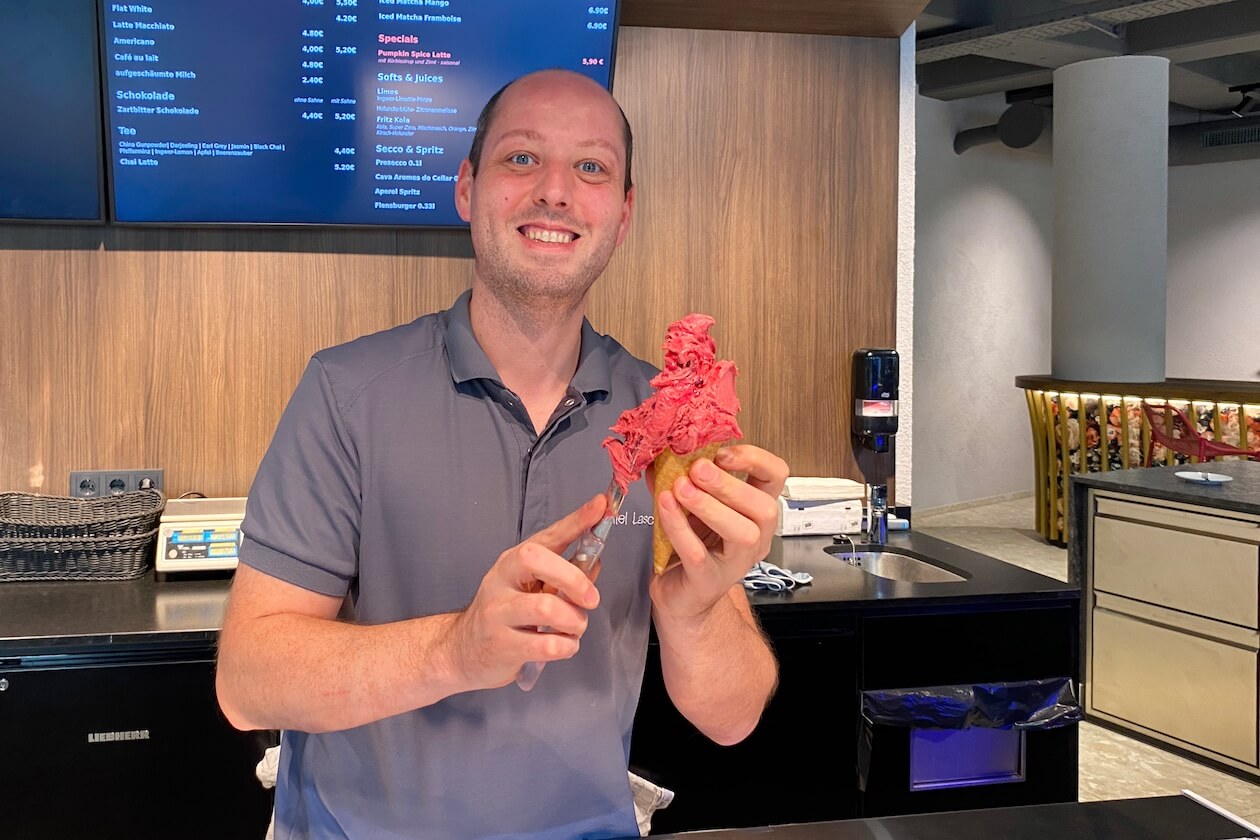 Bäcker- und Konditormeister Daniel Lasch hält ein hausgemachtes Eis hinter der Theke der Confiserie Gordani Lasch in Karlsruhe