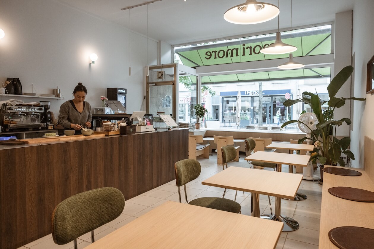 Die Hu schlägt Matcha an der Theke frisch auf, im Hintergrund das große Fenster zur Kaiserstraße