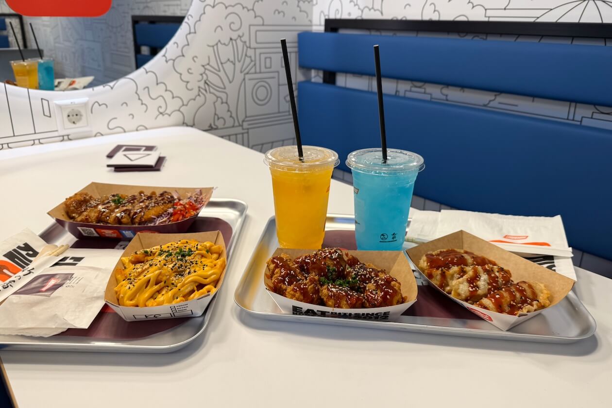 Korean Katsu mit Krautsalat, Korean Cheese Fries, Korean Chicken Bites, Kimchi Mandu und zwei Limonaden auf Tabletts bei Mmaah! Karlsruhe