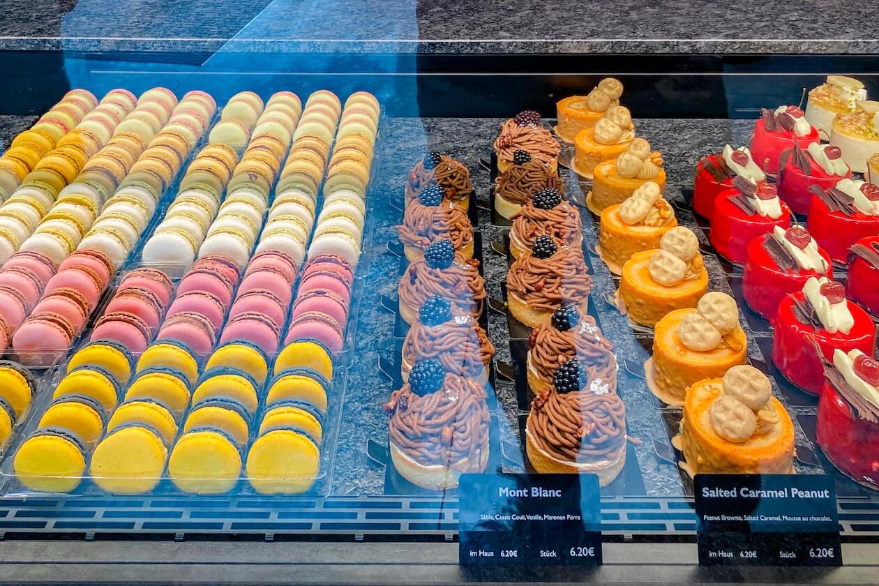 Vitrine mit Macarons, Mont-Blanc-Törtchen, Salted-Caramel-Peanut-Törtchen und Kirsch-Törtchen in der Confiserie Gordani Lasch in Karlsruhe
