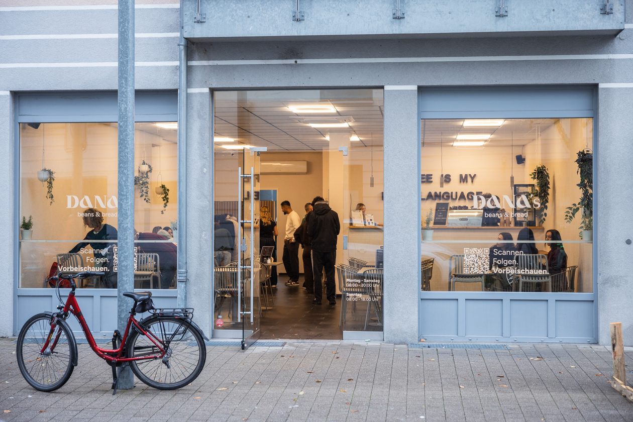 Außenansicht von Dana's Beans & Bread in Karlsruhe mit großen Schaufenstern in der Anna-Lauter-Straße, davor ein rotes Fahrrad