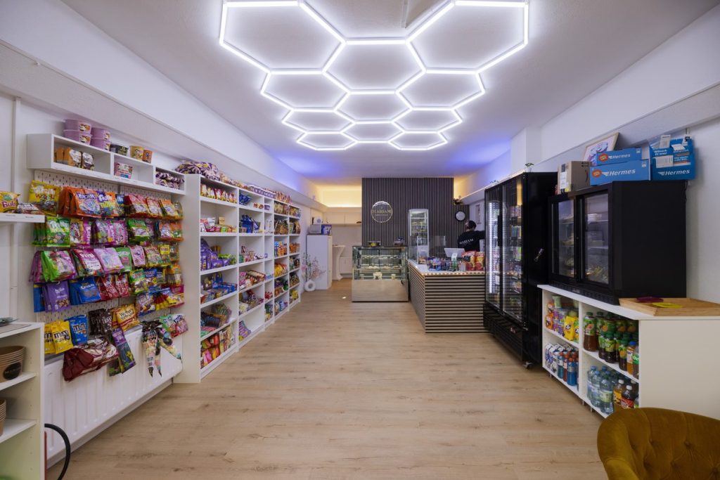 Blick in das Mariam Café & Kiosk in Karlsruhe mit Snackregalen, Kühlschränken und Lichtdecke in Wabenform